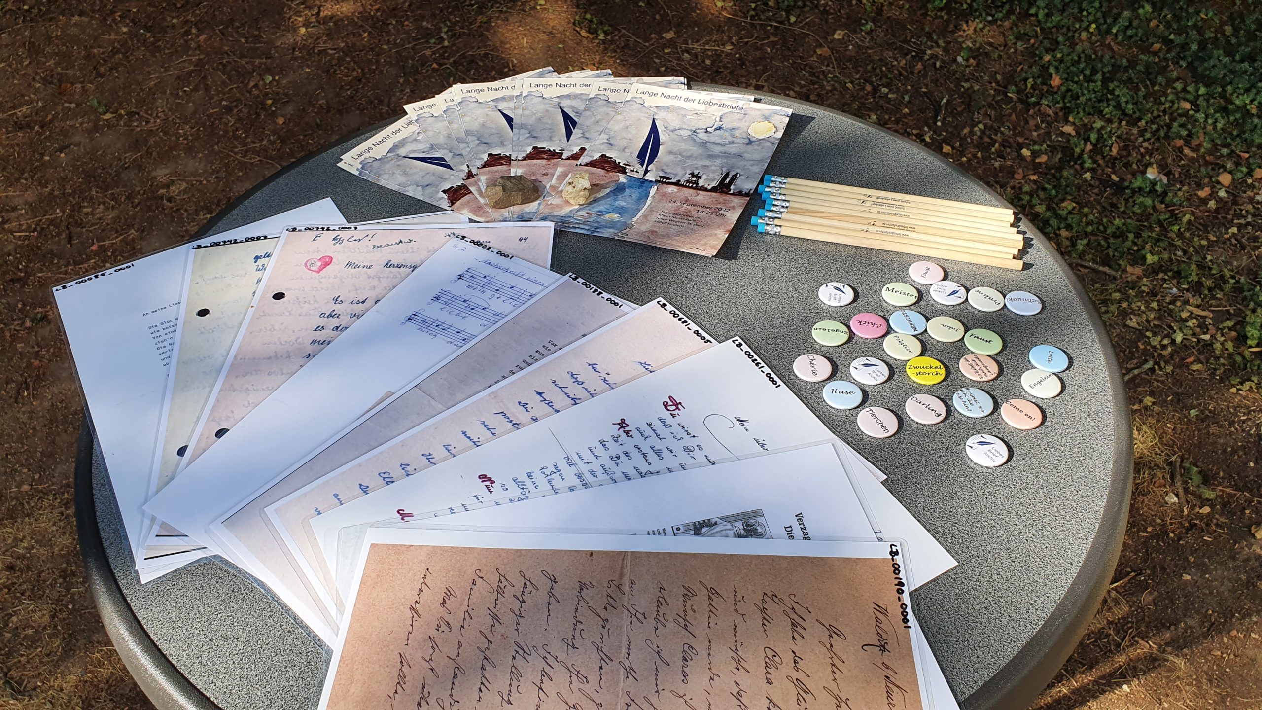 Liebesbriefe, Flyer, Bleistifte und Buttons mit Kosenamen des Liebesbriefarchivs