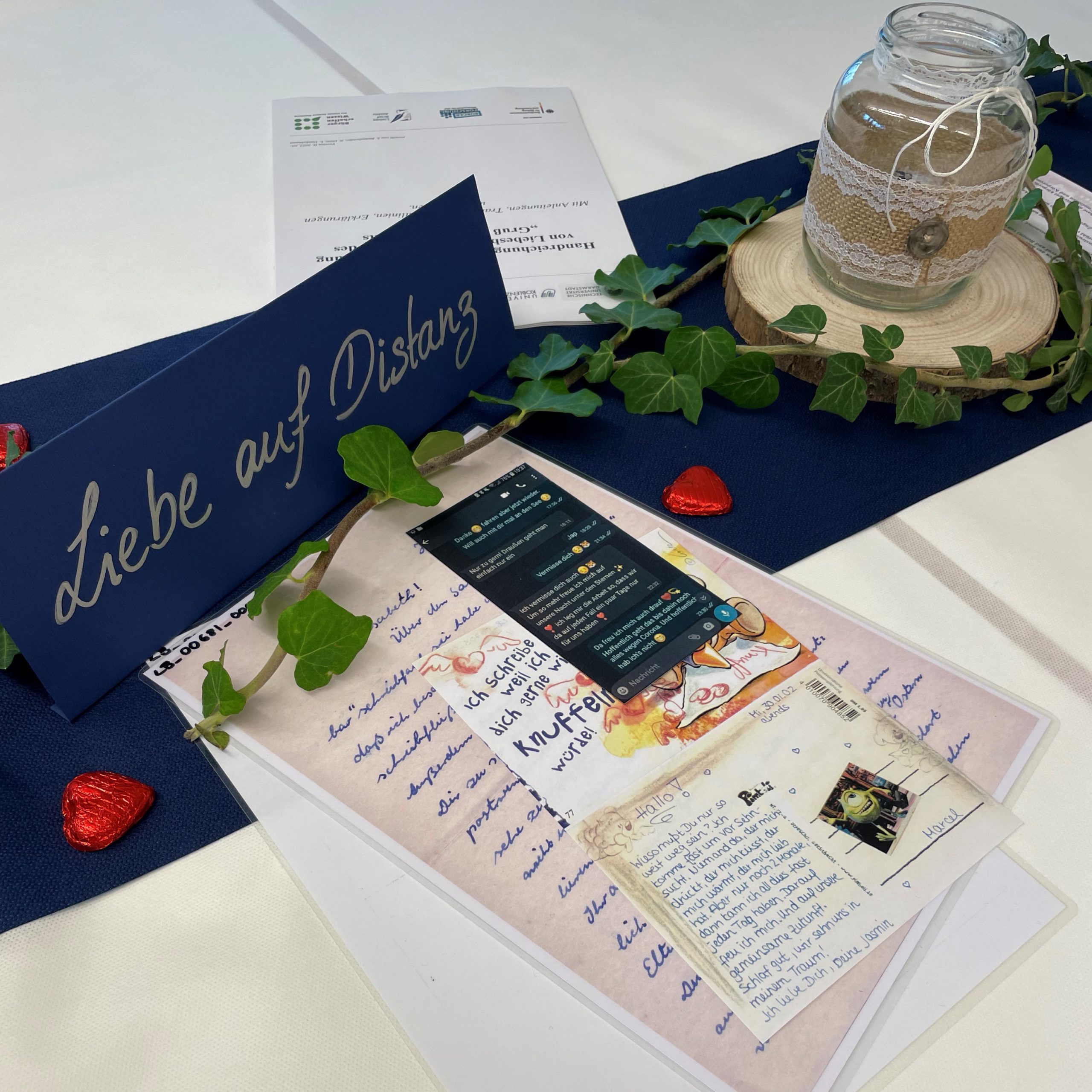 Digitale und handschriftliche Liebesbriefe und Postkarten auf dem Thementisch zu Liebe auf Distanz