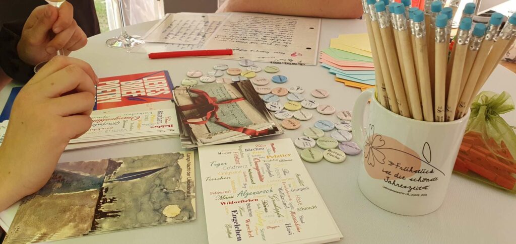 Liebesbriefe, Flyer, Bleistifte und Buttons mit Kosenamen des Liebesbriefarchivs